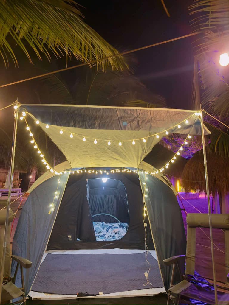 A ready-made glamping tent set up with bedding and lights