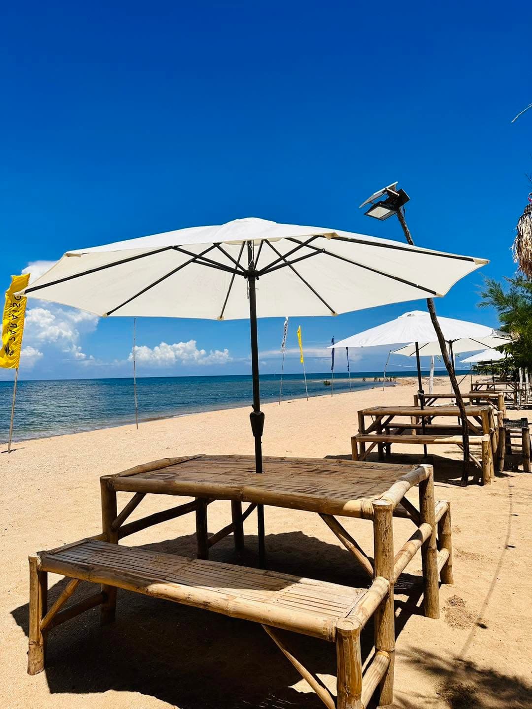 A shaded table and umbrella set up near the beach