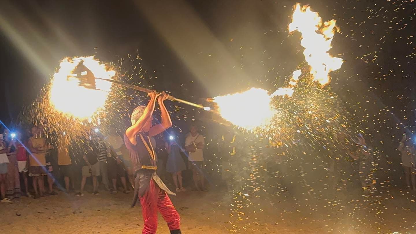 A fire dancer performing on the beach at night