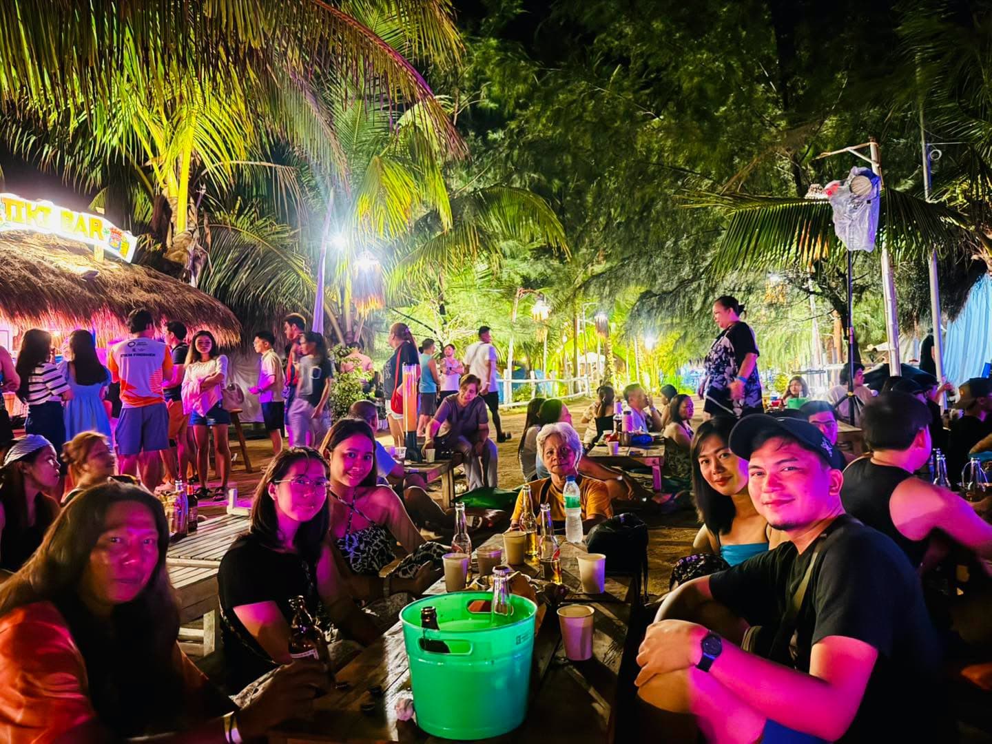 A crowd enjoying live music on the sand at night